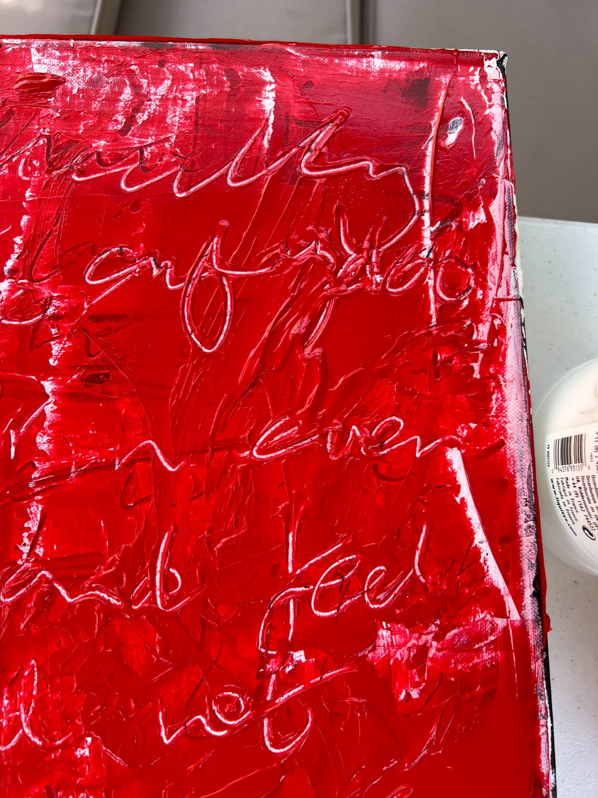 Canvas edge showing layers of red paint and buried writing
